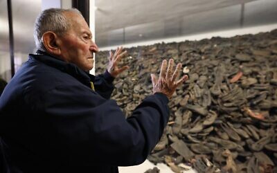 Le survivant de la Shoah Arie Pinsker, 92 ans, regarde la collection de chaussures des victimes exposées à Auschwitz-Birkenau (Crédit : ali Natapov/Neishlos Foundation)