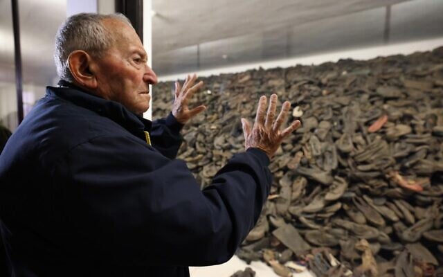 Le survivant de la Shoah Arie Pinsker, 92 ans, regarde la collection de chaussures des victimes exposées à Auschwitz-Birkenau (Crédit : ali Natapov/Neishlos Foundation)