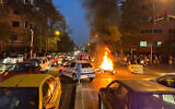 Une moto de police brûle pendant une manifestation, dans le centre de Téhéran, en Iran, le 19 septembre 2022. (Crédit : AP Photo)
