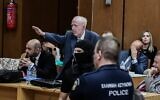 L'avocat d'un ancien eurodéputé de l'Aube dorée emprisonné fait un salut nazi lors d'une audience du procès en appel de dizaines de membres emprisonnés du groupe néonazi grec Aube dorée devant la cour d'appel d'Athènes le 7 octobre 2022. (Crédit : Tatiana Bolari/AFP)