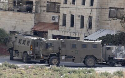 Des véhicules de Tsahal garés près d'un bâtiment pendant une opération à Jénine, en Cisjordanie, le 8 octobre 2022. (Crédit : Jaafar Ashtiyeh/AFP)