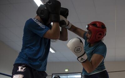 La boxeuse iranienne Sadaf Khadem  donne un coup de poing à son adversaire sur le ring pendant un entraînement au Roc Boxe de Royan, dans l'Ouest de la France, le 3 octobre 2022. (Crédit :  ROMAIN PERROCHEAU / AFP)