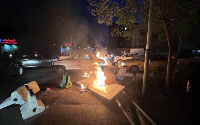 Des objets incendiés dans une rue de la capitale dans le cadre des manifestations géantes en Iran, à Téhéran, le 8 octobre 2022. (Crédit : Photo obtenue par l'AFP hors de l'Iran) Des objets incendiés dans une rue de la capitale dans le cadre des manifestations géantes en Iran, à Téhéran, le 8 octobre 2022. (Crédit : Photo obtenue par l'AFP hors de l'Iran)