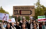 Des manifestants brandissant des pancartes lors d'un rassemblement de soutien aux manifestants en Iran, place de la République, à Paris, le 29 octobre 2022. (Crédit : MOHAMMADREZA DEHDARI / agence de presse Isna / AFP)