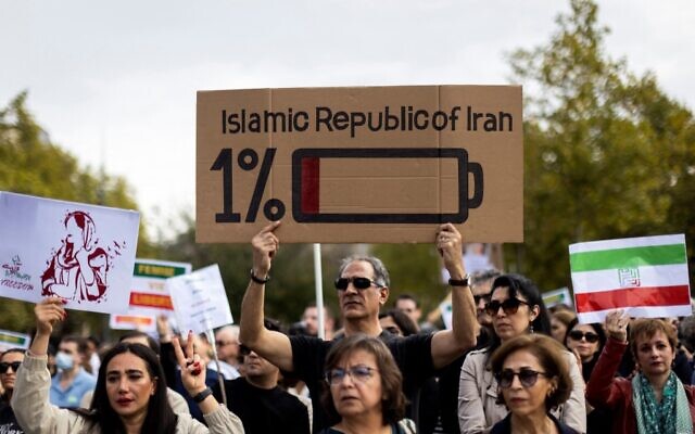 Des manifestants brandissant des pancartes lors d'un rassemblement de soutien aux manifestants en Iran, place de la République, à Paris, le 29 octobre 2022. (Crédit : MOHAMMADREZA DEHDARI / agence de presse Isna / AFP)