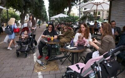 Des gens dans le centre de la ville côtière méditerranéenne d’Israël, Tel Aviv, le 1er décembre 2021. (Crédit : Menahem Kahana/AFP)