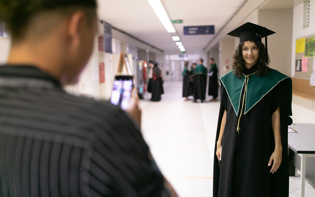 Un étudiant prend la photo d'une diplômée de l'université Milton Friedman University de Budapest, en Hongrie, le 15 juillet 2017. (Crédit : Université Milton Friedman University/via JTA)