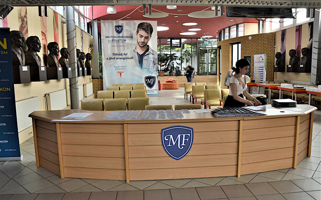 Une employée de l'université Milton Friedman prépare les prospectus pour les visiteurs dans le hall d'accueil de l'institution, le 21 juillet 2021. (Autorisation : Université Milton Friedman/ via JTA)