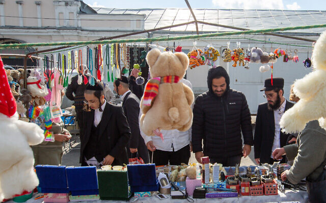  Des touristes cherchant des souvenirs dans un bazar d'Ouman. (Crédit : David Saveliev/ JTA)
