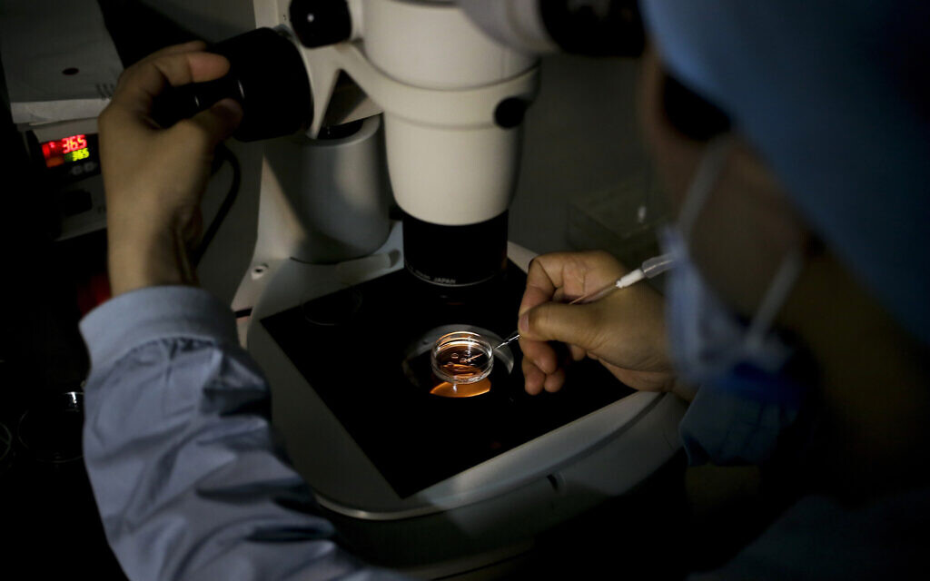 Un membre du personnel médical recueillant un ovule sur un plat de laboratoire lors d'un traitement de l'infertilité par fécondation in vitro (FIV) pour un patient dans un hôpital de Pékin, le 24 avril 2016. (Crédit : Andy Wong/AP Photo)