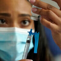 Sur cette photo du 19 mai 2021, on voit  une infirmière se préparer à administrer un vaccin contre la COVID-19 de Moderna, dans un centre de vaccination installé au stade Gillette de Foxborough, dans le Massachusetts. (Crédit : AP Photo/Steven Senne)