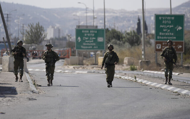 Des soldats israéliens bloquent le poste de contrôle de Hawara, l'entrée principale de la ville de Naplouse en Cisjordanie, le 12 octobre 2022. (Crédit : AP Photo/Majdi Mohammed) Des soldats israéliens bloquent le poste de contrôle de Hawara, l'entrée principale de la ville de Naplouse en Cisjordanie, le 12 octobre 2022. (Crédit : AP Photo/Majdi Mohammed)