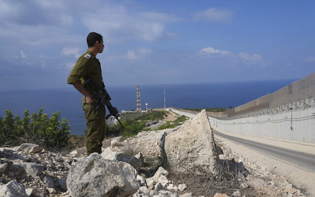 Un soldat israélien à côté de la clôture à la frontière d'Israël avec le Liban à Rosh Hanikra , le 14 octobre 2022. (Crédit : AP Photo/ Tsafrir Abayov) Un soldat israélien à côté de la clôture à la frontière d'Israël avec le Liban à Rosh Hanikra , le 14 octobre 2022. (Crédit : AP Photo/ Tsafrir Abayov)