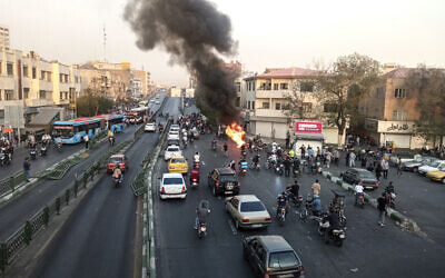 Une moto du Basij, le groupe paramilitaire iranien, incendiée pendant une manifestation dénonçant la mort de Mahsa Amini, 22 ans, décédée alors qu'elle se trouvait sous la garde de la police des mœurs, à Téhéran, le 10 octobre 2022. (Crédit : AP Photo/Middle East Images)