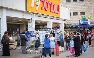 Illustration : Des personnes patientent devant un supermarché Shufersal à Safed le 6 avril 2020. (Crédit: David Cohen/Flash90)