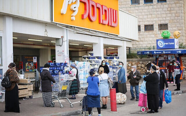 Illustration : Des personnes patientent devant un supermarché Shufersal à Safed le 6 avril 2020. (Crédit: David Cohen/Flash90)