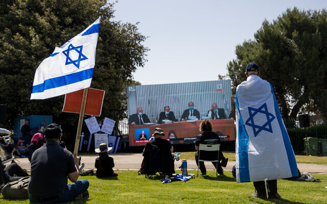 Des Israéliens regardent une audience de la Cour suprême aux abords de la Knesset, le 3 avril 2020. (Crédit :  Yonatan Sindel/Flash90)