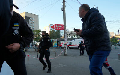 Des Ukrainiens courent alors qu'un drone explose contre un immeuble à Kiev, le 17 octobre 2022. (Crédit : AP Photo/Efrem Lukatsky)