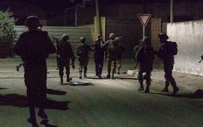 Des soldats israéliens arrêtant un Palestinien recherché en Cisjordanie, le 3 octobre 2022. (Crédit : Armée israélienne)