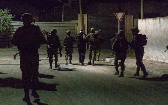 Des soldats israéliens arrêtant un Palestinien recherché en Cisjordanie, le 3 octobre 2022. (Crédit : Armée israélienne)