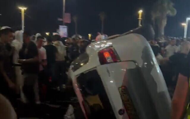 Une voiture retournée par une foule qui a attaqué le conducteur arabe et les passagers, à Bat Yam, le 4 octobre 2022. (Crédit : Capture d'écran utilisée conformément à la clause 27a de la loi sur le droit d'auteur) Une voiture retournée par une foule qui a attaqué le conducteur arabe et les passagers, à Bat Yam, le 4 octobre 2022. (Crédit : Capture d'écran utilisée conformément à la clause 27a de la loi sur le droit d'auteur)