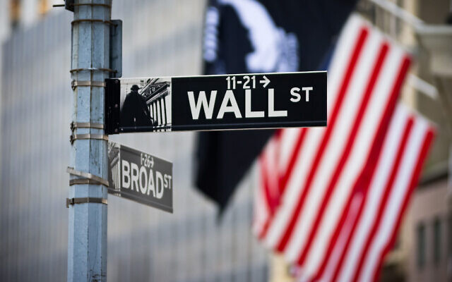 Illustration : L'enseigne Wall Street avec le drapeau américain dans le quartier financier du Lower Manhattan. (Crédit : Damien Verrier/iStock by Getty Images) Illustration : L'enseigne Wall Street avec le drapeau américain dans le quartier financier du Lower Manhattan. (Crédit : Damien Verrier/iStock by Getty Images)