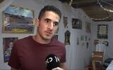 Yonatan Nizri se tenant dans sa soucca, un jour après avoir été blessé dans une attaque terroriste à Beit El, le 15 octobre 2022. (Crédit : La chaîne publique Kan)