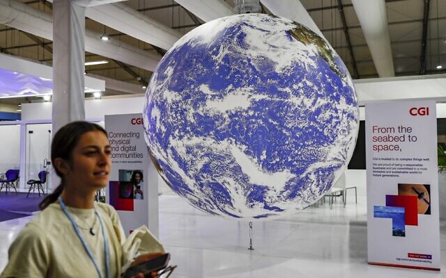 Un participant passe devant une maquette du globe terrestre au Centre international de conventions de Sharm el-Sheikh, le premier jour du sommet sur le climat COP27, dans la station balnéaire égyptienne de Sharm el-Sheikh, sur la mer Rouge, le 6 novembre 2022. (Crédit : Mohammed ABED / AFP) Un participant passe devant une maquette du globe terrestre au Centre international de conventions de Sharm el-Sheikh, le premier jour du sommet sur le climat COP27, dans la station balnéaire égyptienne de Sharm el-Sheikh, sur la mer Rouge, le 6 novembre 2022. (Crédit : Mohammed ABED / AFP)