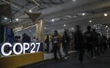 Des participants marchent à l'intérieur du Centre international de convention de Sharm el-Sheikh pendant la conférence sur le climat COP27, le 9 novembre 2022. (Crédit : Mohammed ABED / AFP)