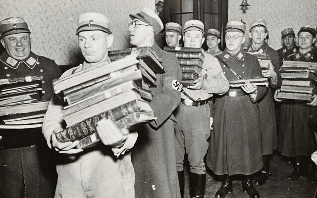 Des nazis embarquent des livres juifs, vraisemblablement pour les brûler, pendant la Nuit de Cristal, probablement dans la ville de Fürth, en Allemagne, le 10 novembre 1938. (Crédit : Yad Vashem via AP)