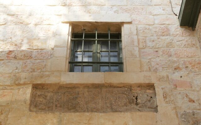 Alors que l'original se trouve dans un musée à Istanbul, cette réplique fidèle de la pierre de la frontière de Guézer se trouve sur le mur de la maison du XIXe siècle construite par le missionnaire et architecte Conrad Schick pour sa famille. (Crédit : Shmuel Bar-Am)