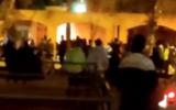 Un homme se tient debout alors que ce qui semble être l'ancienne maison - aujourd'hui transformée en musée - du premier dirigeant suprême de l'Iran, Ruhollah Khomeini, est incendié par des manifestants, à Khomein, en Iran, le 17 novembre 2022. (Crédit : Twitter/capture d'écran : utilisé conformément à la clause 27a de la loi sur le droit d'auteur)
