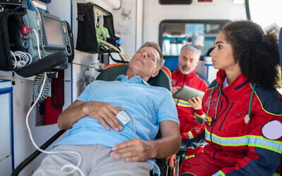 Un secouriste surveille un patient et vérifie sa fréquence cardiaque. Illustration (Crédit : Zinkevych/iStock/Getty Images)