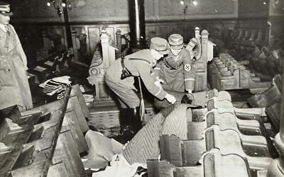 Des nazis et des civils allemands assistent au saccage de biens juifs pendant la Nuit de Cristal, probablement dans la ville de Fürth, en Allemagne, le 10 novembre 1938. (Crédit : Yad Vashem via AP)