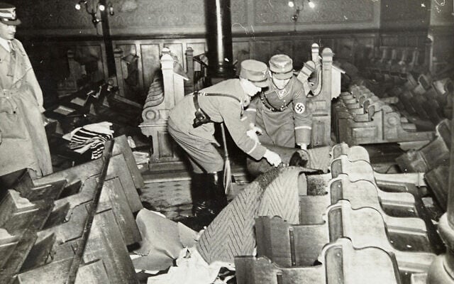 Des nazis et des civils allemands assistent au saccage de biens juifs pendant la Nuit de Cristal, probablement dans la ville de Fürth, en Allemagne, le 10 novembre 1938. (Crédit : Yad Vashem via AP)
