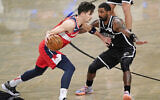 Kyrie Irving, défenseur des Brooklyn Nets, face à Deni Avdija, attaquant des Washington Wizards, lors d'un match de NBA de pré-saison, le 13 décembre 2020, à New York. (Crédit : AP Photo/Kathy Willens)