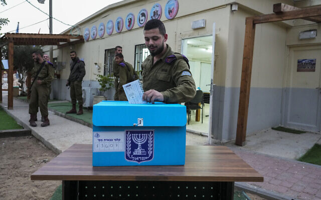 Un soldat israélien votant sur une base de l'armée près du kibboutz Kerem Shalom, près de la frontière avec la bande de Gaza, le 31 octobre 2022. (Crédit : AP Photo/Tsafrir Abayov) Un soldat israélien votant sur une base de l'armée près du kibboutz Kerem Shalom, près de la frontière avec la bande de Gaza, le 31 octobre 2022. (Crédit : AP Photo/Tsafrir Abayov)