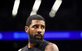 Le gardien des Brooklyn Nets, Kyrie Irving, regarde à l'extérieur pendant la deuxième mi-temps d'un match de basket-ball de la NBA contre les Indiana Pacers, le 31 octobre 2022, à New York. (Crédit : AP/Jessie Alcheh)