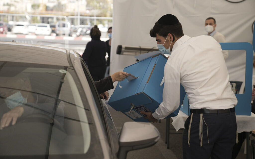 Un homme positif au COVID vote lors des élections israéliennes à Jérusalem, le 1er novembre 2022. (Crédit : AP Photo/Mahmoud Illean)