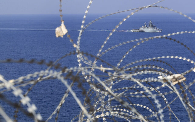 Illustration : Un navire de la marine de la FINUL vu à travers les barbelés de patrouille en mer Méditerranée, à côté d'un poste de l'ONU le long de la frontière connue sous le nom de Ras Naqoura, où les délégations libanaise et israélienne se sont réunies pour finaliser un accord sur la frontière maritime, au large de la ville de Naqoura, au sud du Liban, le 27 octobre 2022. (Crédit : Mohammed Zaatari/AP) Illustration : Un navire de la marine de la FINUL vu à travers les barbelés de patrouille en mer Méditerranée, à côté d'un poste de l'ONU le long de la frontière connue sous le nom de Ras Naqoura, où les délégations libanaise et israélienne se sont réunies pour finaliser un accord sur la frontière maritime, au large de la ville de Naqoura, au sud du Liban, le 27 octobre 2022. (Crédit : Mohammed Zaatari/AP)
