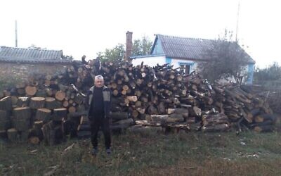 Un Juif âgé dans la région de Dnipro en Ukraine, devant le bois de chauffage livré par JDC dans le cadre de l'aide aux Juifs ukrainiens pendant l'hiver. (Courtoisie du JDC via la JTA)