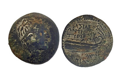 Une pièce ancienne frappée à l'époque du roi séleucide Antiochus IV, découverte dans la maison de Kiryat Shmona d'un voleur présumé, dans le nord d'Israël, le 23 novembre 2022. (Crédit : Nir Distelfeld, Autorité israélienne des Antiquités)