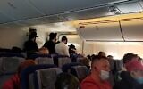 À l’intérieur du vol Lufthansa à destination de Francfort, des hommes juifs orthodoxes priant à l’arrière de l’avion. (Crédit : JTA)