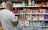 Illustration : Un homme regarde des produits laitiers en faisant ses courses dans un supermarché Rami Levy. (Nati Shohat/Flash90)