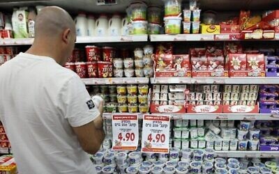 Illustration : Un homme regarde des produits laitiers en faisant ses courses dans un supermarché Rami Levy. (Nati Shohat/Flash90)