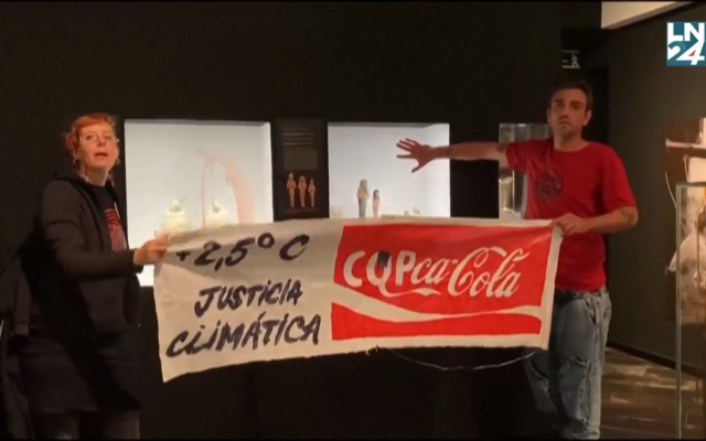 Deux jeunes activistes, un homme et une femme appartenant au collectif "Futuro Vegetal", ont aspergé à l'aide de bouteilles en plastique de Coca-Cola la cage en verre de faux pétrole, puis les murs de faux sang, afin de dénoncer l'inaction des gouvernements réunis pour la COP27 en Egypte face au changement climatique, à Madrid, le 14 novembre 2022. (Capture d'écran Twitter) Deux jeunes activistes, un homme et une femme appartenant au collectif "Futuro Vegetal", ont aspergé à l'aide de bouteilles en plastique de Coca-Cola la cage en verre de faux pétrole, puis les murs de faux sang, afin de dénoncer l'inaction des gouvernements réunis pour la COP27 en Egypte face au changement climatique, à Madrid, le 14 novembre 2022. (Capture d'écran Twitter)