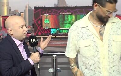 Le journaliste de Kan, Moav Vardi, (à gauche), avec le chanteur colombien Maluma (à droite) qui quitte le plateau d'interview, au Qatar, le 18 novembre 2022 (capture d’écran/Kan utilisé conformément à l’article 27a de la Loi sur les droits d’auteur)