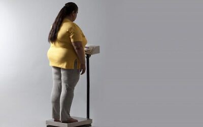 Illustration : Une femme se tenant sur une balance. (Crédit : Shutterstock)