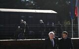 Le président français Emmanuel Macron, à droite, marche à côté du président de la Fondation du Camp des Milles Alain Chouraqui sur le site de commémoration du  Camp des Milles à  Aix-en-Provence, dans le sud-est de la France, le 5 décembre 2022. (Crédit : CHRISTOPHE SIMON / POOL / AFP)