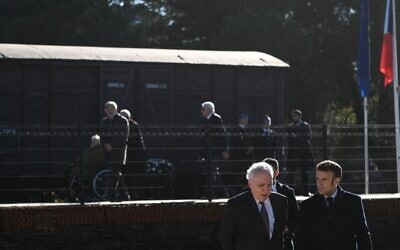 Le président français Emmanuel Macron, à droite, marche à côté du président de la Fondation du Camp des Milles Alain Chouraqui sur le site de commémoration du  Camp des Milles à  Aix-en-Provence, dans le sud-est de la France, le 5 décembre 2022. (Crédit : CHRISTOPHE SIMON / POOL / AFP)